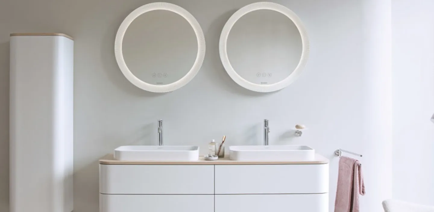 Duravit doppel Waschbecken mit zwei runden Spiegeln in einem hellen Badezimmer.