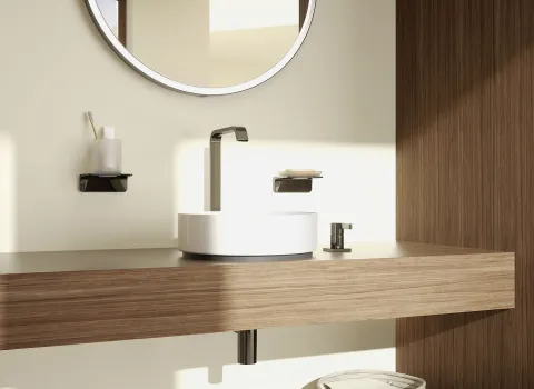 Moderne Waschtisch-Armatur in einem minimalistischen Badezimmer, montiert auf einem weißen Aufsatzwaschbecken auf einer Holzplatte.