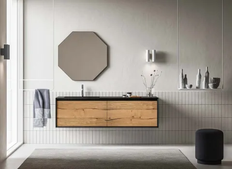 Modernes Badezimmer mit schwebendem Waschtisch in Holzoptik, schwarzer Waschtischplatte und geometrischem Wandspiegel.