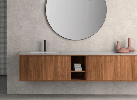 Langer, freischwebender Waschtisch aus dunklem Holz mit rundem Spiegel und minimalistischer Armatur in modernem Badezimmer von Stocco.