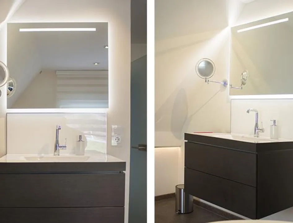 Modernes Badezimmer mit stilvollem Waschtisch in dunklem Holzton, beleuchtetem Spiegel und verchromter Armatur – minimalistisches Design mit warmem Licht.